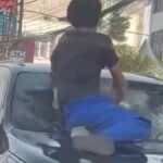 Seorang pria berdiri di atas kap Toyota Fortuner hitam sambil memukul kaca depan kendaraan yang telah retak, saat mobil tersebut dikerumuni warga di kawasan Tanah Abang, Jakarta Pusat.