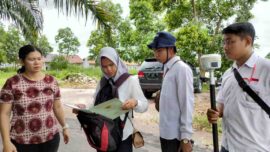 Petugas Badan Pertanahan Nasional (BPN) melakukan pengukuran bidang tanah milik warga sebagai bagian dari proses pendaftaran tanah. Foto: InfoPublik.