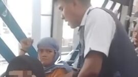 Seorang pria berhijab diamankan petugas setelah kepergok penumpang saat merogoh tas korban. Foto: Tangkap layar IG @kriminal.jakarta