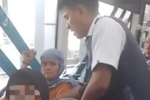 Seorang pria berhijab diamankan petugas setelah kepergok penumpang saat merogoh tas korban. Foto: Tangkap layar IG @kriminal.jakarta