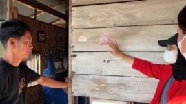 Mahasiswa PBL III FKM Unhas mengedukasi warga sambil memasang stiker larangan merokok di rumah warga Desa Baringeng, Kecamatan Lilirilau, Kabupaten Soppeng, Kamis (2/7/2026).